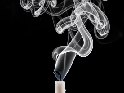 Candle snuff smoke rising in complex spiraling pattern