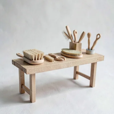 Papercraft scene of a paper-cut brush maker's bench with layered handles and bri