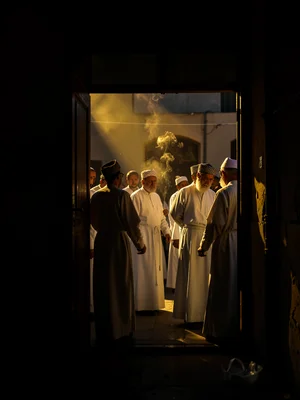 Dramatic light through darkness in Addis Ababa, Ethiopia, Orthodox clergy in whi