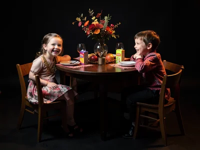 Kids table at thanksgiving, small chairs, paper placemats, juice boxes, happy