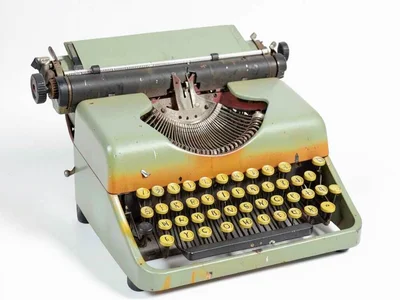 Old typewriter printed in sage green and ochre yellow with halftone keys and vis