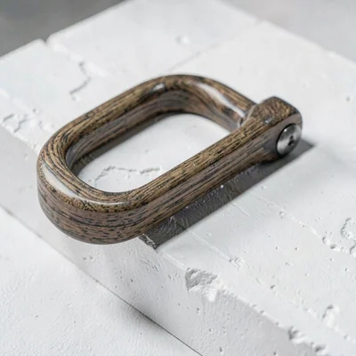 Mineralcut detail of a polished ash D-handle on white plaster, hard sidelight