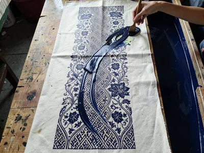 An overhead view of a semi-finished batik length — kawung motif in progress, hal
