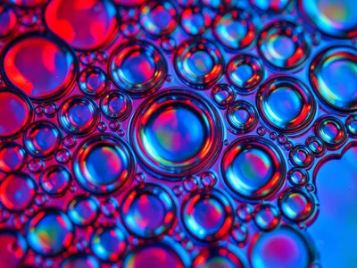 Oil on water with strobing colored LED beneath, freezing the floating cells in a