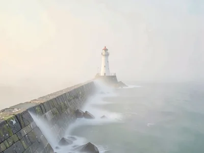 Pierhead light at the end of a long stone breakwater, the breakwater dissolving