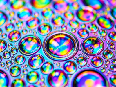 Sunscreen oil on water surface creating iridescent summer cells