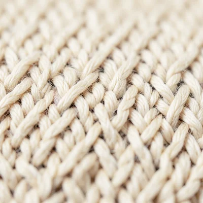 Knitted wool macro texture, individual fibers visible, warm cream color, soft fo