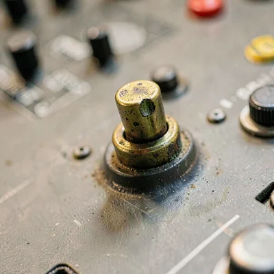 Detail of a tarnished brass switch toggle on a broadcast console