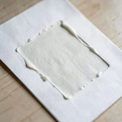 Paper macro of a single freshly pulled print laid flat, ink slightly raised on t