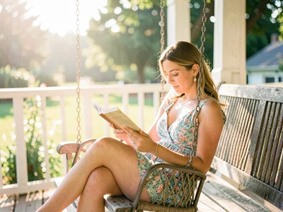 A woman reading on a porch swing in summer afternoon