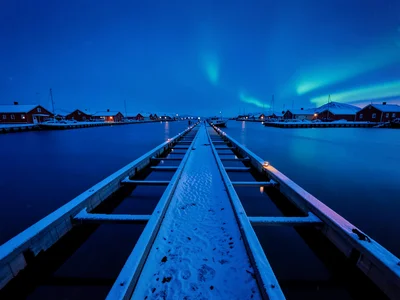 Polar night blue hour in Tromso, Norway, the geometric grid of a boat dock exten