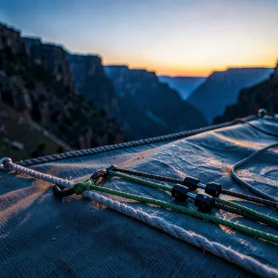 Quiet rack arrangement on a rope tarp at twilight, cams and slings catching last