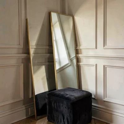 Soft wash of a corner mirror leaning against panelled wainscoting with a velvet 