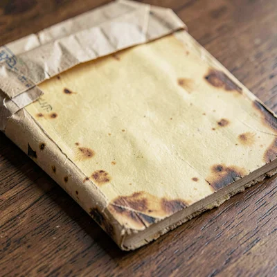 Paper close-up of a yellowed back-issue with foxed edges, slipped from its bag