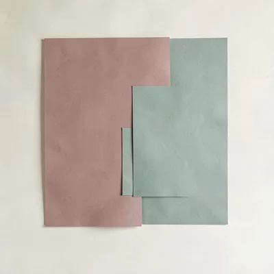 Color-block of two large overlapping rectangles in dusty rose and sage on a crea