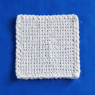 single chunky woven-cotton washcloth folded into a square top-down on a saturate