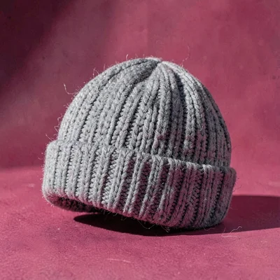 single chunky knit beanie in heather grey at three-quarter angle on a punchy ras