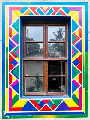Window framed by painted surround — geometric border in electric primary colors