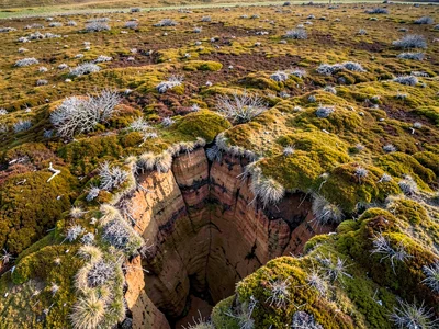 Active peat erosion creating cliff edges visible from above