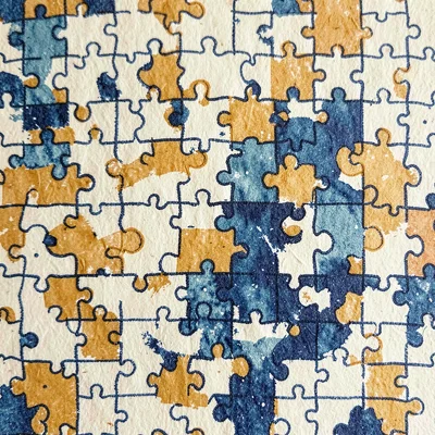 Riso pattern motif of repeating interlocked puzzle pieces in indigo and ochre ov