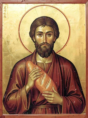 Frontal portrait of a baker holding a loaf of bread aloft with a golden halo