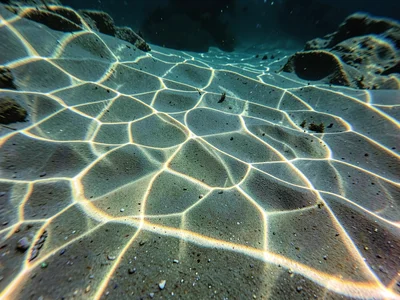 Sharp focused light points dancing on rippled sand