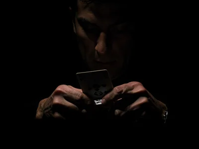 Hands dealing cards in darkness