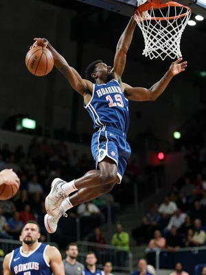 Basketball player dunking from below