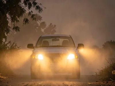 Car headlights glowing with halos through evening dust