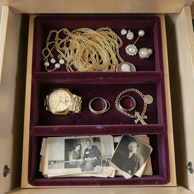 Inside a grandmother's jewelry box viewed from above, the lid open revealing thr