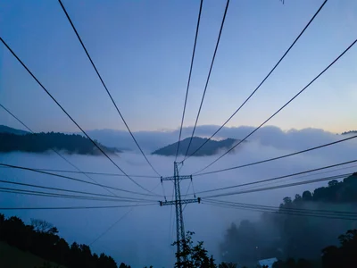 Power lines creating geometric pattern above fog