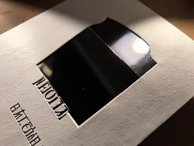 Black foil with mirror finish, reflecting environment as dark moody mirror, stud