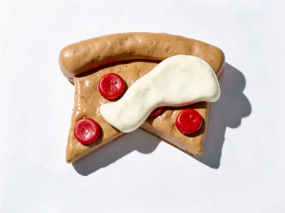 Wide chunky clay slice of pizza pepperoni in tan tone with cherry-red squat dots