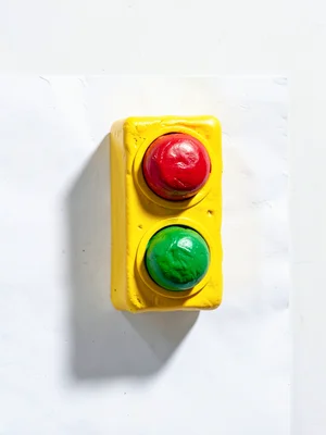 Industrial chunky clay traffic light in primary yellow with stubby cherry-red, y