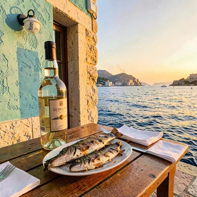 Adriatic limestone warmth, Dubrovnik honey stone, Grilled fish on outdoor table,