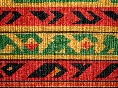 Kente strip detail flat-lay — warp and weft texture visible, top-down macro