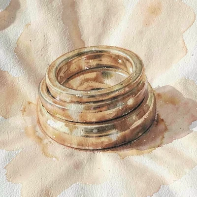 Trio of stacking rings nested together on raw silk, soft caramel tones
