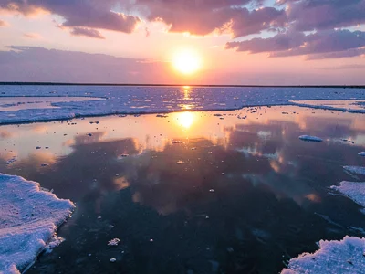 Sunrise creating glowing orb in mirror landscape