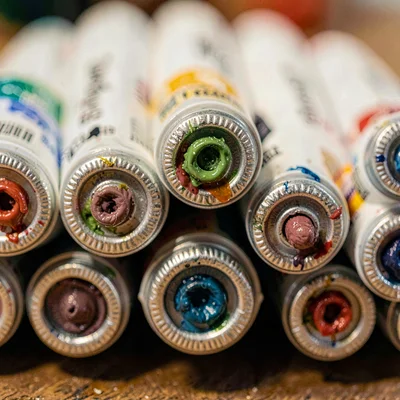 Macro of a stack of oil paint tubes seen end-on, crimped foil ends with pigment