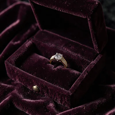Velvet jewelry box open, ring nestled in plush interior, precious container