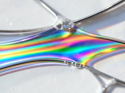 Extreme closeup of soap film drainage zone, narrow band where colors transition 