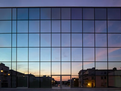 Full facade as gradient canvas at dusk