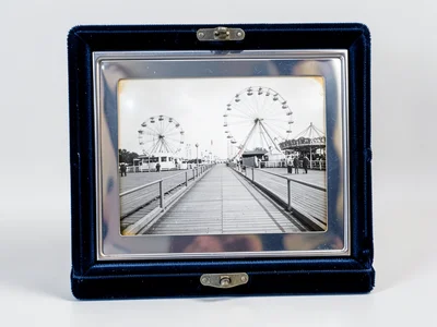 Daguerreotype-style image of summer boardwalk, silver tones, carnival rides
