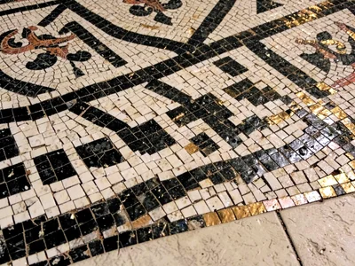 Close-up of an ancient Roman floor mosaic border — geometric meander pattern in 