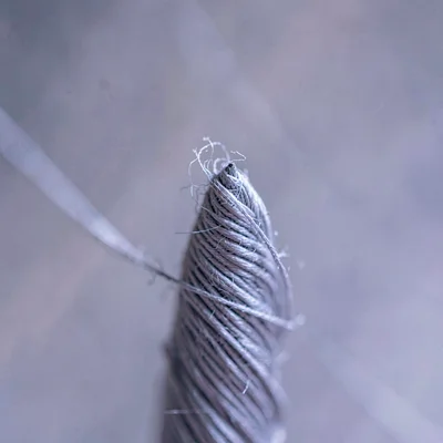 Cross macro of thread cone tip showing the spiral wind in cool gray-violet