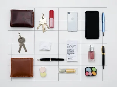 Contents of a woman's handbag: wallet, keys, lipstick, phone, tissues, receipts,