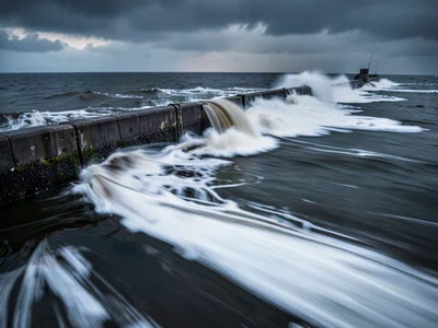 Storm surge against seawall as dramatic blur