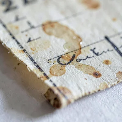 Surface macro of an antique scroll fragment with faded ink and water staining