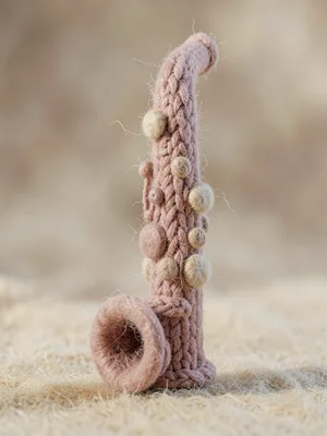 Reed-tipped dusty-rose knit clarinet with chunky-knit segments and felted key bu
