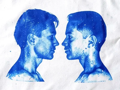 Two profiles facing each other in cyanotype — negative space between them